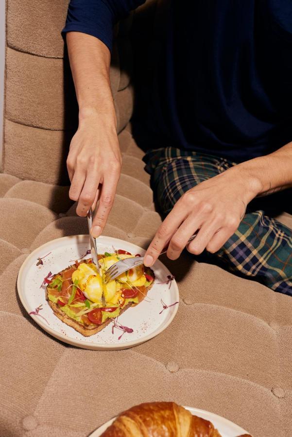 Sanderson London Kültér fotó A person using a knife and fork to cut food